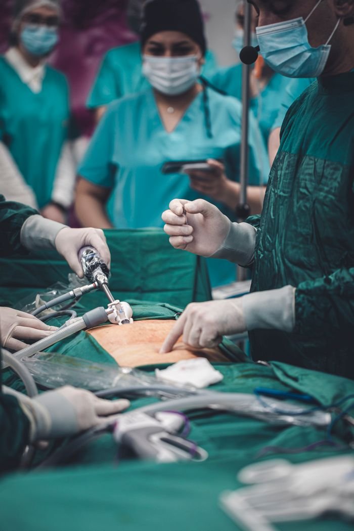 why-choose-us Medical professionals conducting surgery with advanced equipment in an operating room setting.