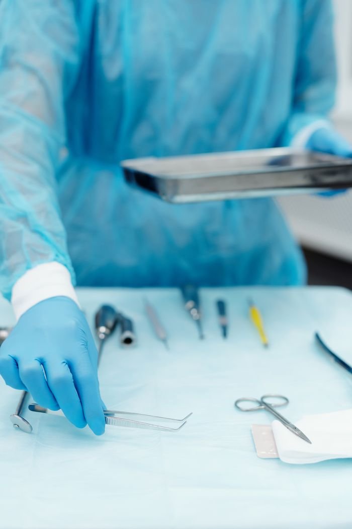 Close-up of a dental professional arranging sterilized tools on a tray in a clinic.