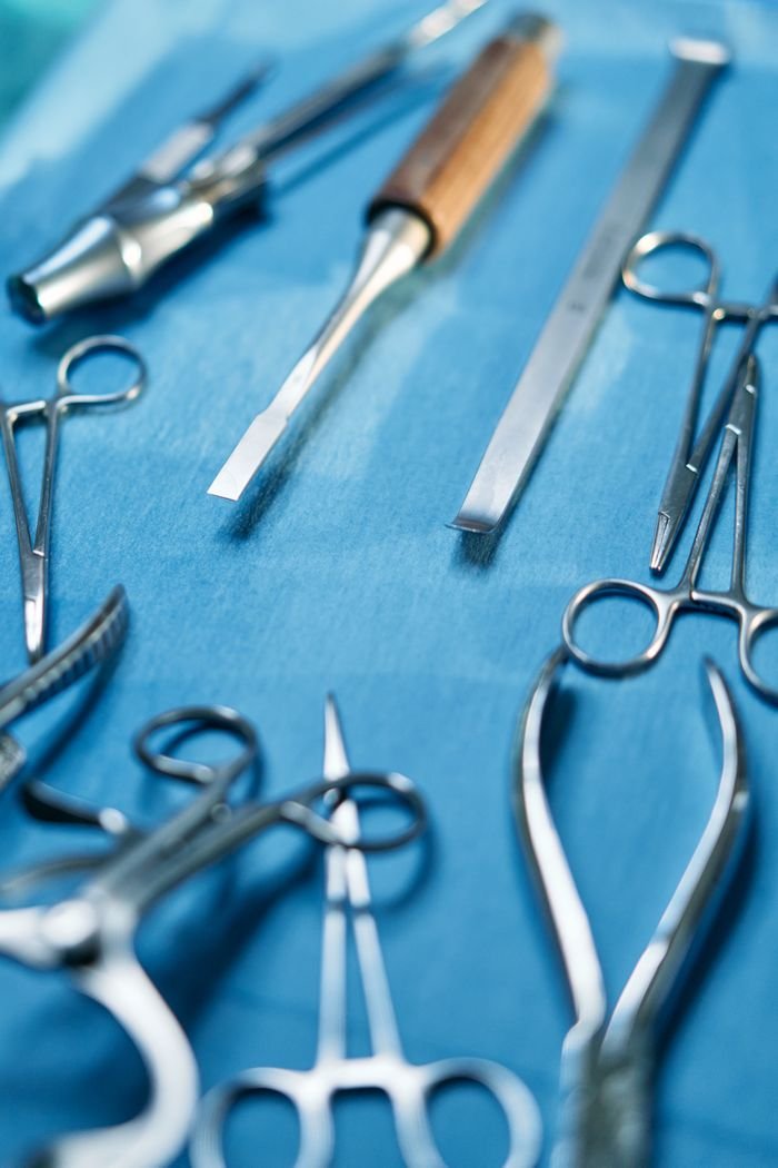 services-01 A detailed view of stainless steel dental and surgical instruments on a blue background.